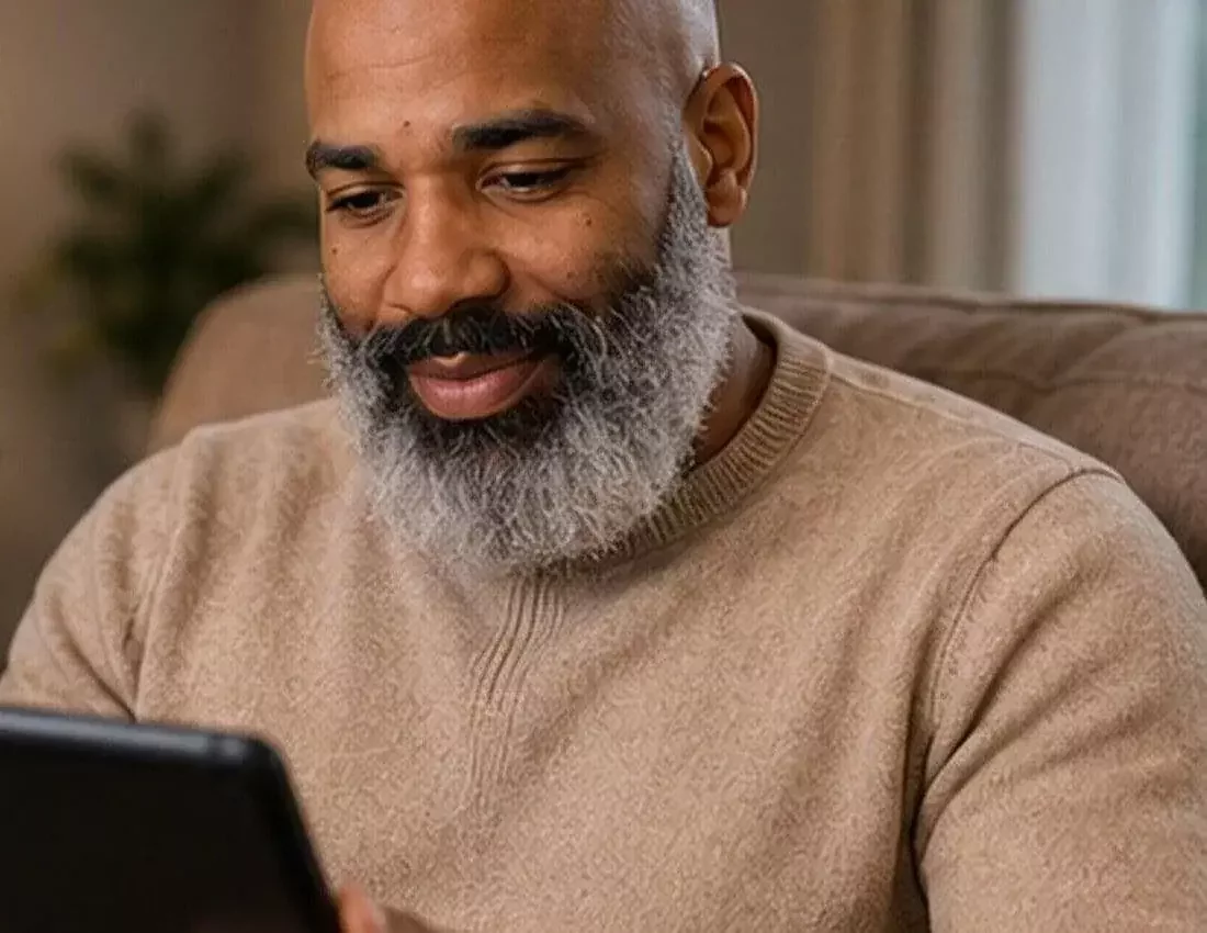 Lawrence Joy Jr., founder of Joynity, smiling while using a tablet